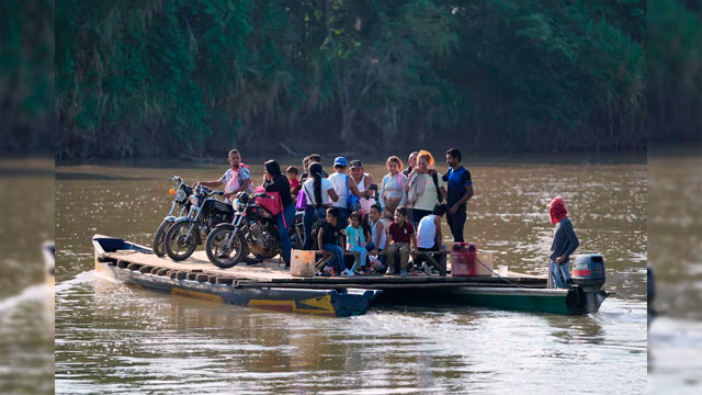 Pobladores cruzan un río hacia Venezuela desde Tibú, Colombia